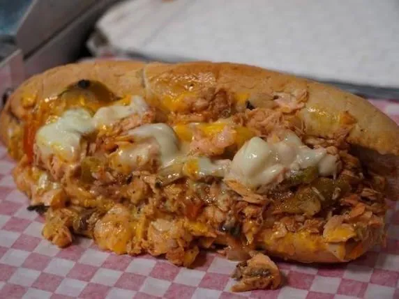 A Buffalo chicken cheesesteak on checkered paper