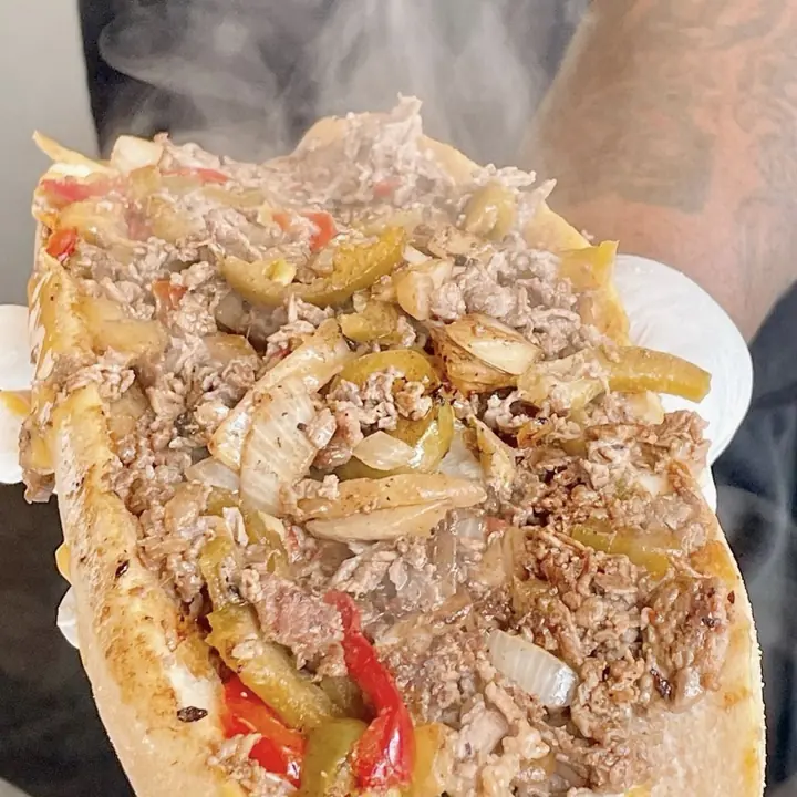 A steaming Deezy's cheesesteak with peppers and fried onions