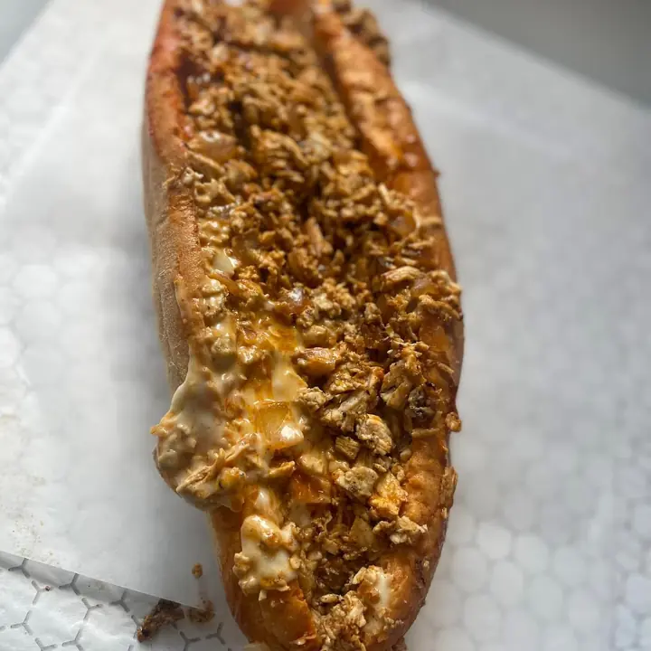 A Deezy's chicken cheesesteak on white paper