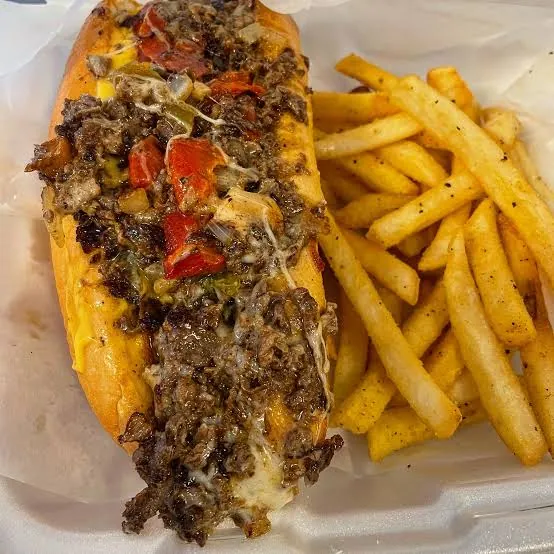 A pepper cheesesteak with a side of fresh-cut fries